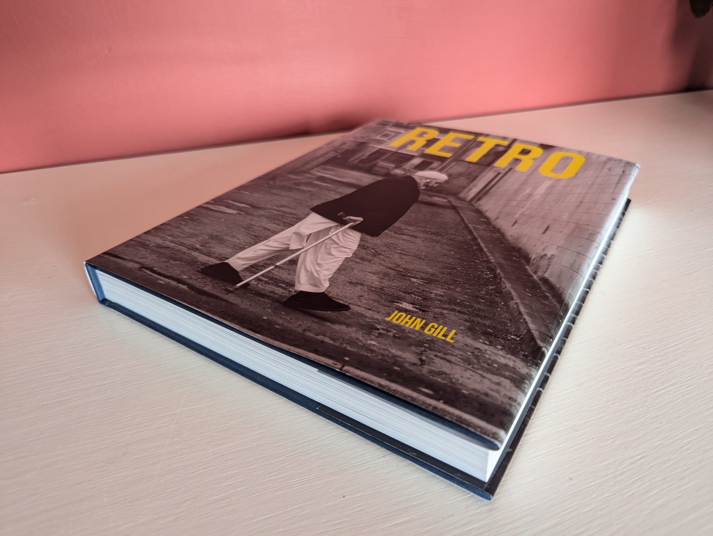 A review of the RETRO book 4 A hardcover book titled "Retro" by John Gill, featuring a black and white photo of a person walking with a cane on the cover.